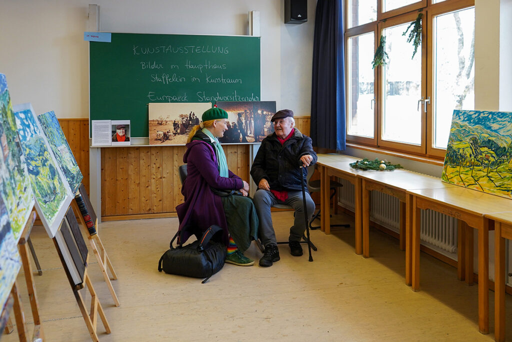 Pfarrer Klaus Boersch, Initiator des  Weihnachtsmarktes, im Gespräch mit ehemaligen Schülerinnen und Schülern.